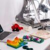 MacBook Pro beside 3D printer